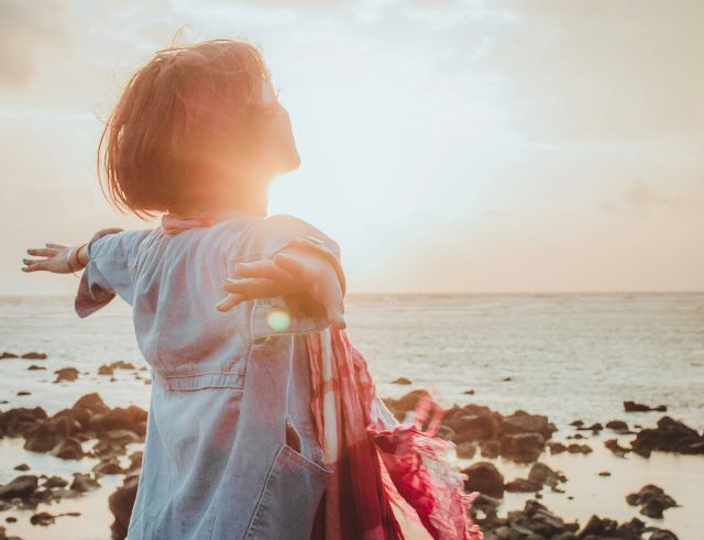 Mujer brazos abiertos al sol - requisito necesario para ser persona